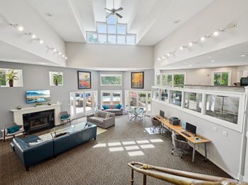 A spacious room with a fireplace, couches, and a ceiling fan.